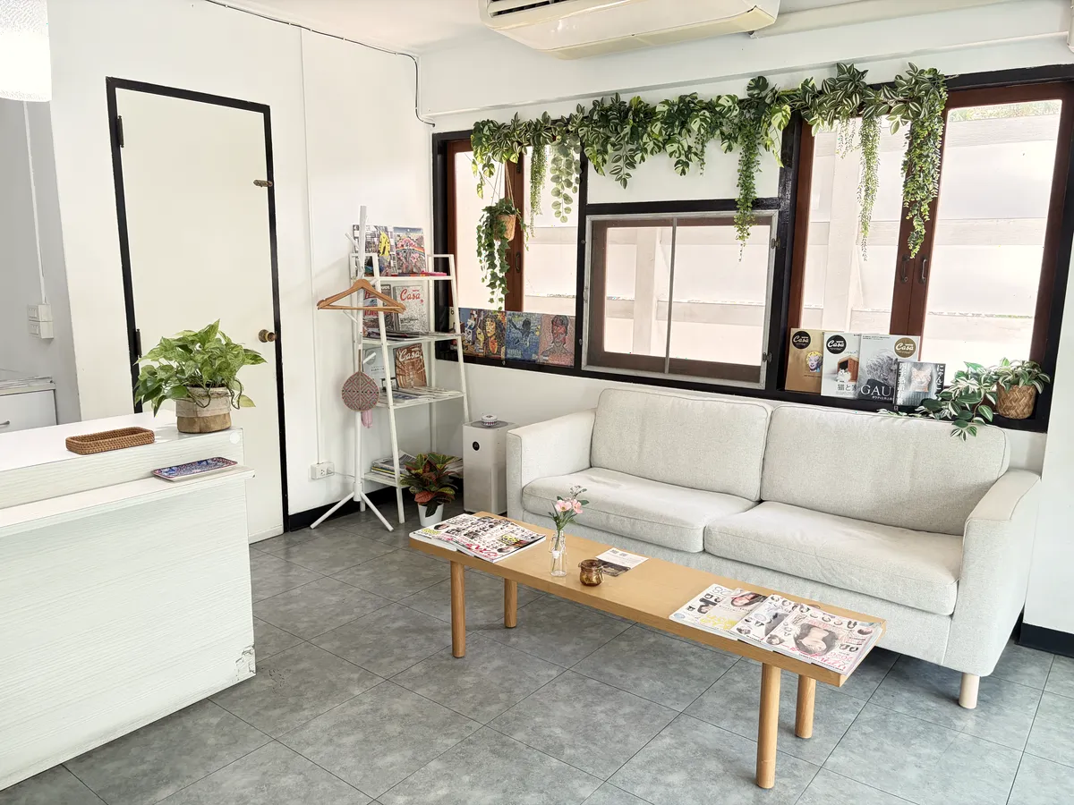 BALCONY トンロー店の待合。窓辺のグリーンと白いソファ